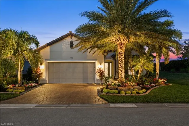 a front view of a house with a yard garage and outdoor seating