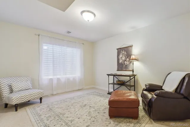a living room with furniture and a floor to ceiling window