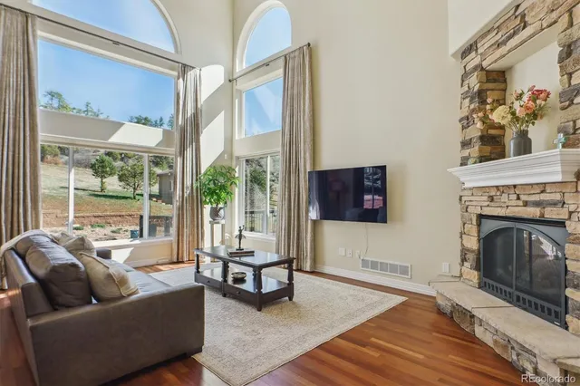 a living room with furniture a fireplace and a flat tv screen next to a window