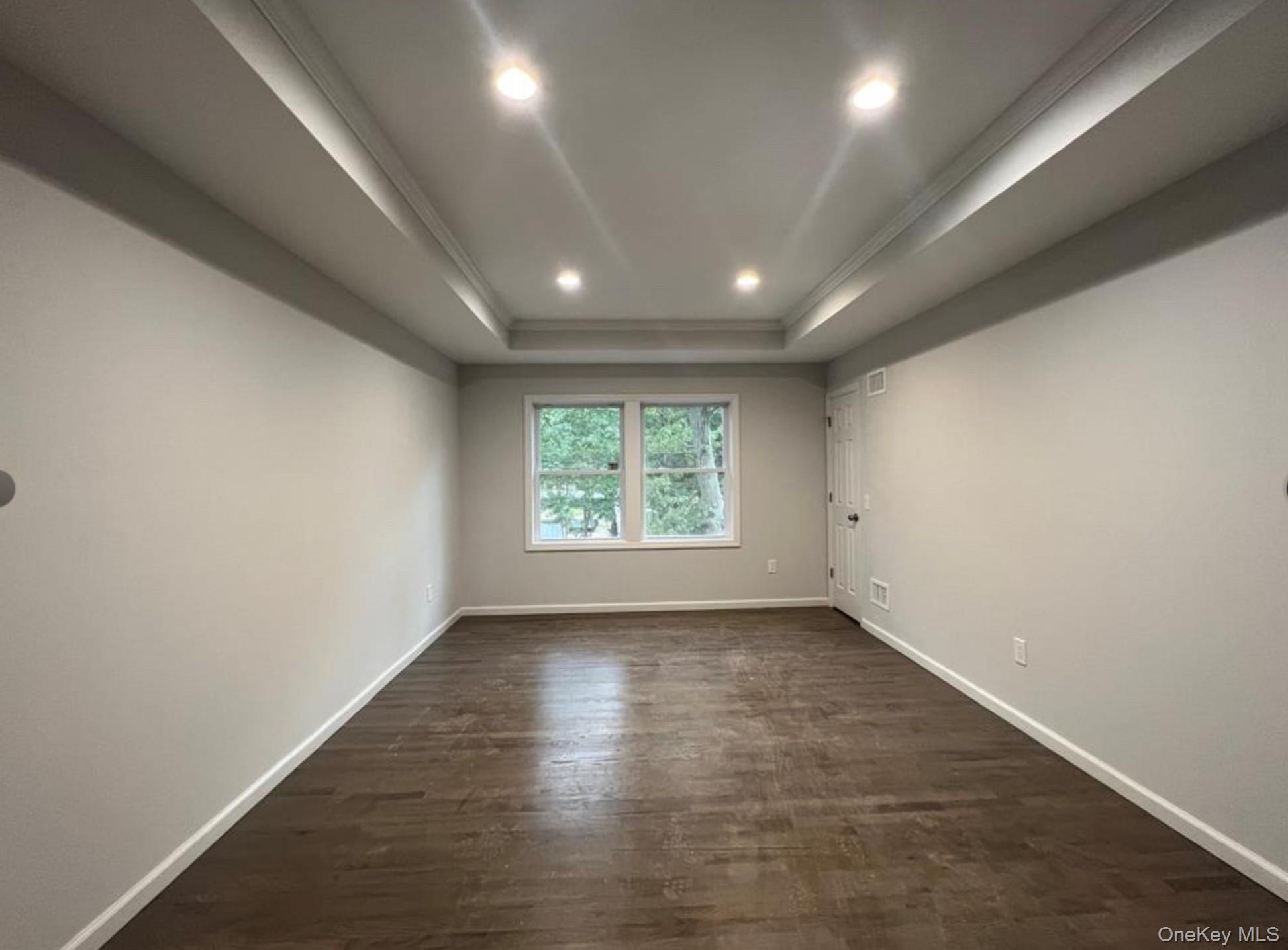 492 Blue Point Road Farmingville, NY 11738 - Photo 8 of 9 an empty room with wooden floor and windows