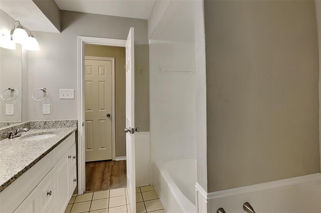 2705 South Colfax Circle Plano, TX 75075 - Photo 11 of 19 a bathroom with a granite countertop sink a mirror and a bathtub