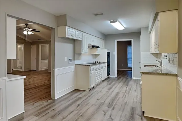 a kitchen with a sink cabinets and wooden floor