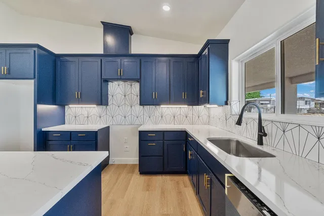 a kitchen with a sink a counter space appliances and cabinets