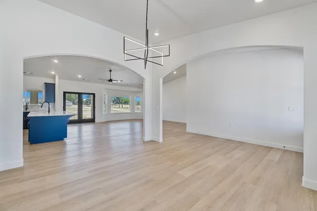 a kitchen with stainless steel appliances granite countertop a sink a stove and white cabinets with wooden floor