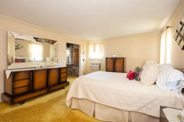 a bedroom with a bed and a large mirror on dresser