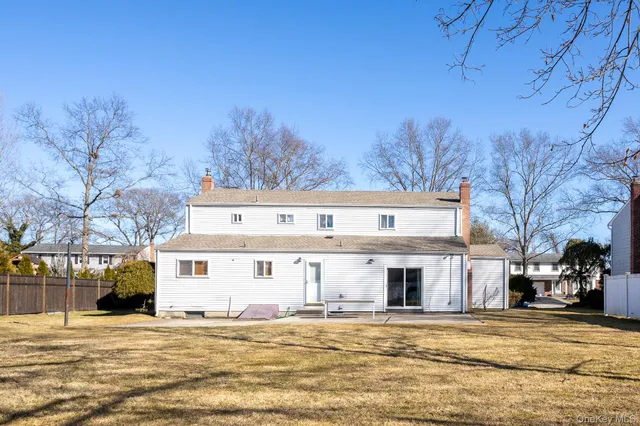 a view of a big house with a big yard and large tree