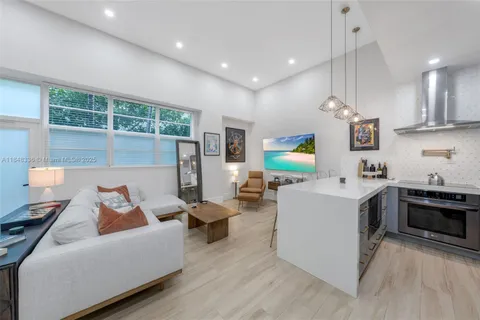 a living room with furniture and kitchen view