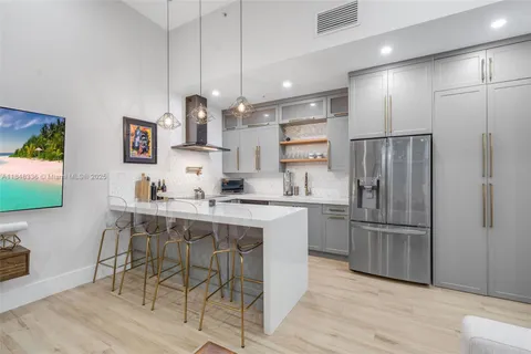 a kitchen with stainless steel appliances granite countertop a sink and a refrigerator