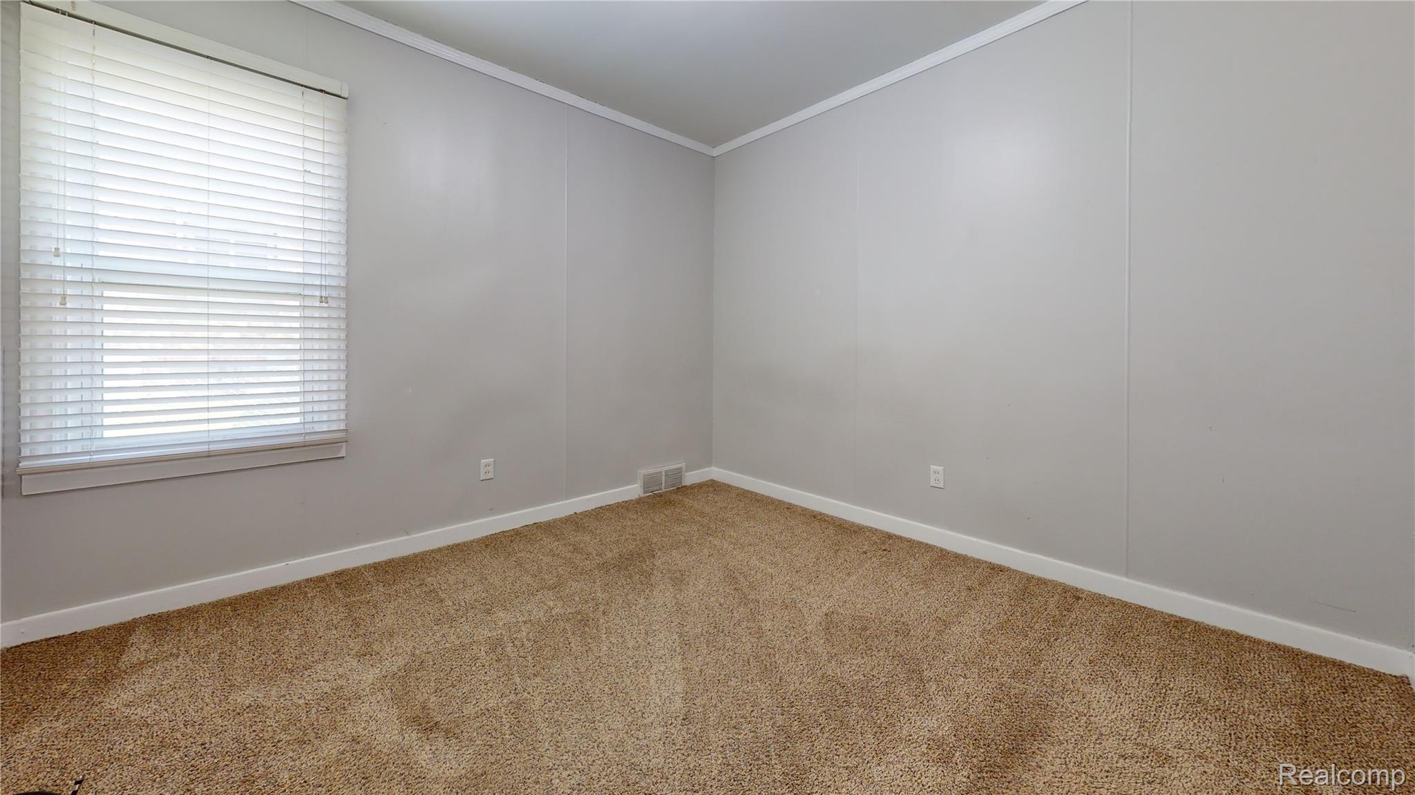 25771 Peter Kaltz Road Warren, MI 48091 - Photo 11 of 16 Spare room featuring ornamental molding and light colored carpet