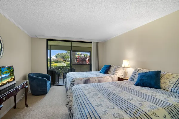 a bedroom with two beds and a large window