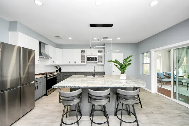 a kitchen with granite countertop a counter space dining table and stainless steel appliances