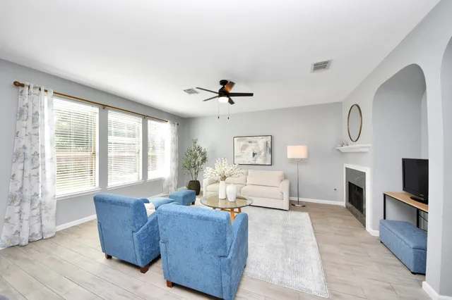 a living room with furniture a fireplace and a large window