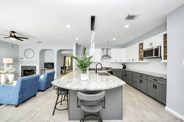 a kitchen with granite countertop white cabinets and stainless steel appliances