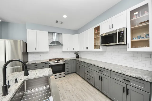 a kitchen with stainless steel appliances granite countertop a stove and a sink