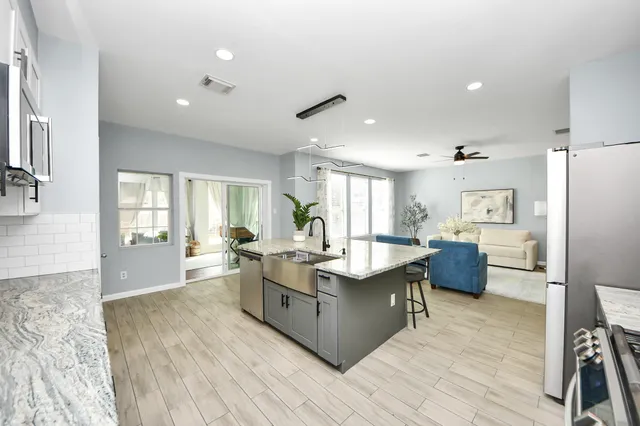 a large living room with stainless steel appliances granite countertop a couch and wooden floor