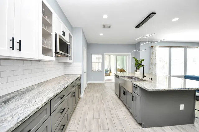a spacious kitchen with stainless steel appliances granite countertop a lot of counter space and a sink