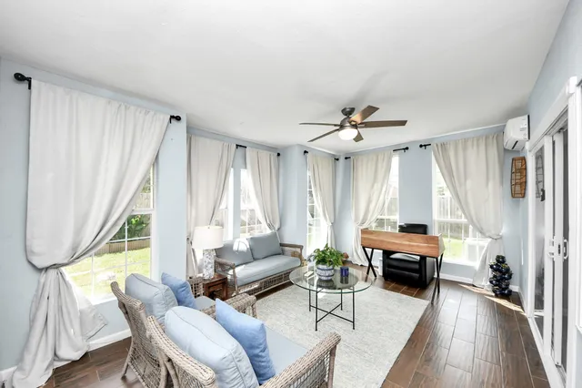 a living room with furniture a large window and a wooden floor