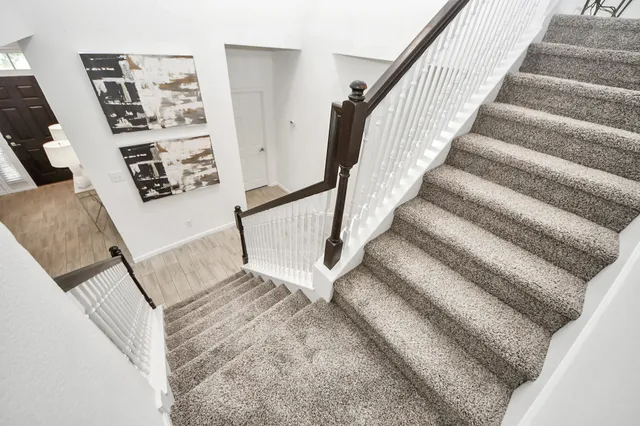 a view of staircase with lots of frames on wall