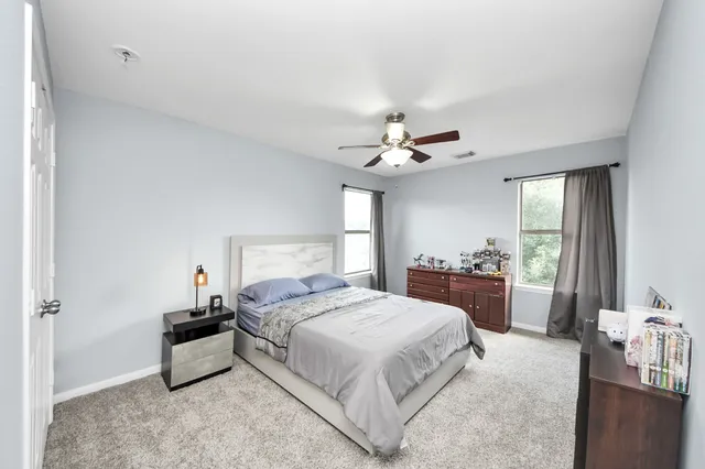 a spacious bedroom with a bed and a chandelier