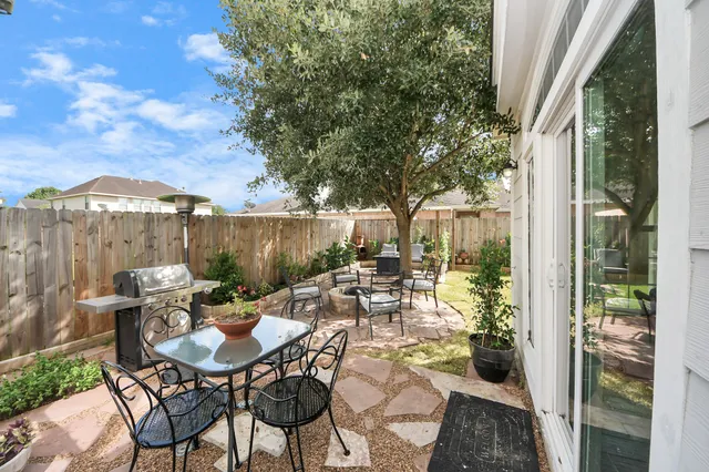 a view of a patio with a table and chairs and couches with wooden fence