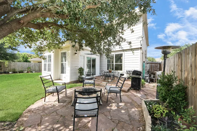 a view of house with backyard and outdoor seating
