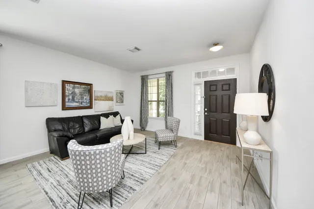 a living room with furniture and a wooden floor