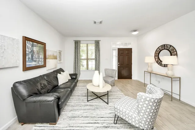 a living room with furniture a window and a potted plant