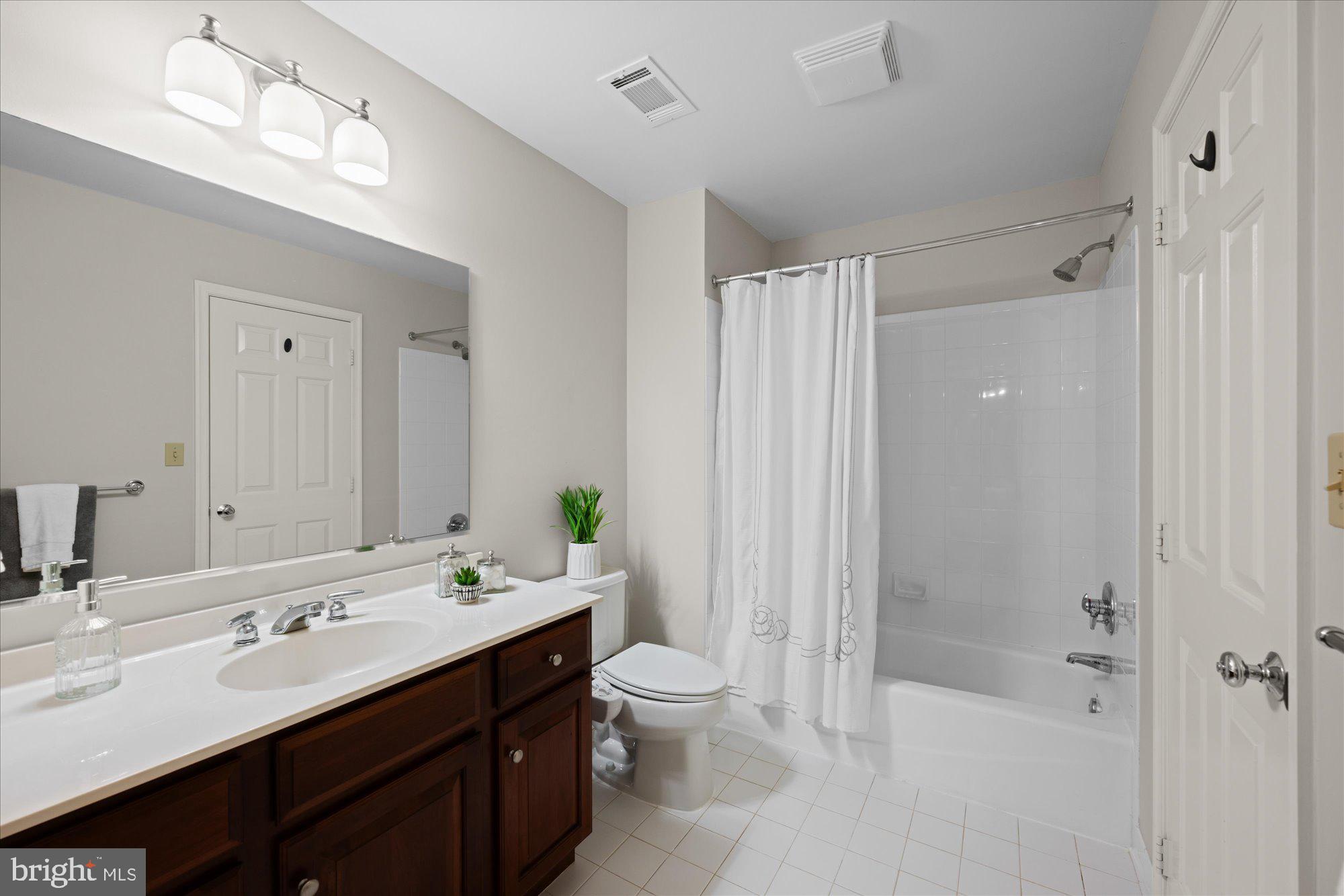 7822 Hidden Meadow Terrace Potomac, MD 20854 - Photo 21 of 29 a bathroom with a double vanity sink toilet mirror and shower