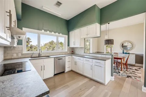 a kitchen with stainless steel appliances granite countertop a stove a refrigerator and a sink