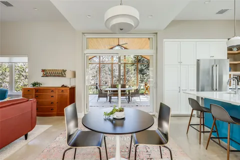 a dining room with furniture a rug and a floor to ceiling window