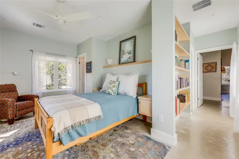 a bed sitting in a bedroom next to a window