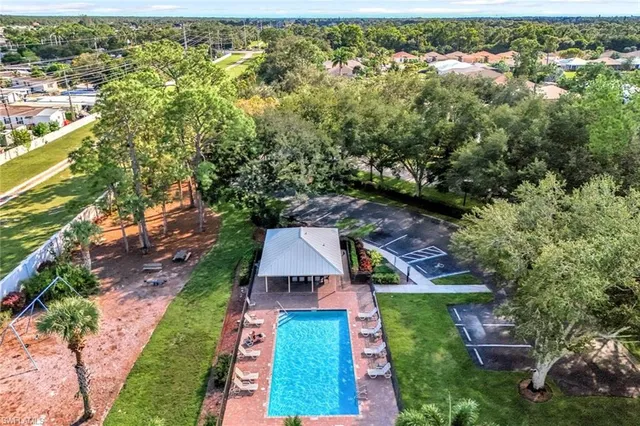 an aerial view of residential houses with outdoor space and trees