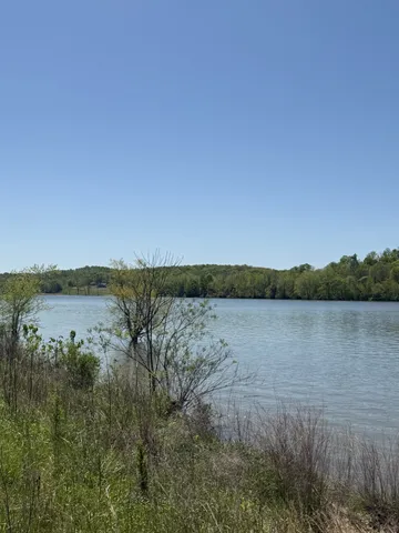 a view of a lake and green valley