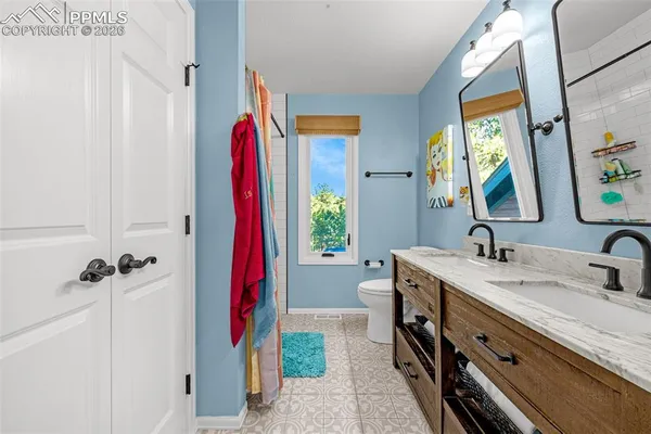 a bed sitting in a spacious bedroom next to a window