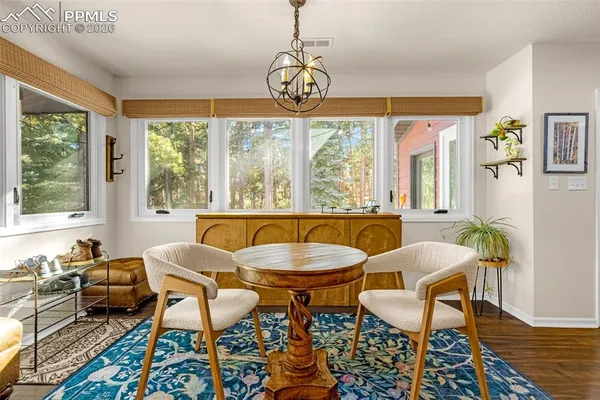 a dining room with furniture a chandelier and wooden floor