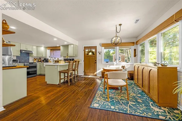 a kitchen with a stove a sink and wooden floor