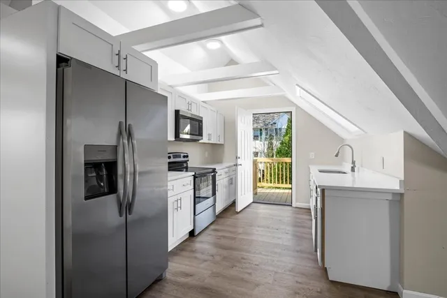 a kitchen with stainless steel appliances a refrigerator sink and microwave