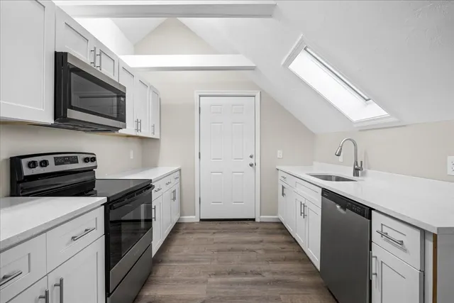 a kitchen with stainless steel appliances granite countertop a sink and a stove top oven
