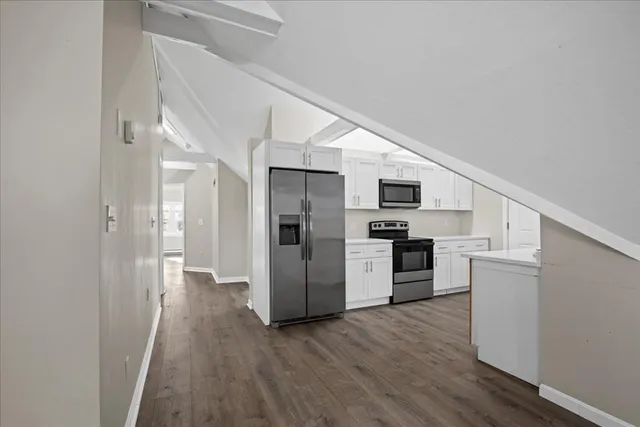 a view of a hallway with wooden floor and staircase