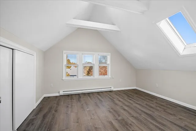 a view of a hallway to an empty room with wooden floor and closet