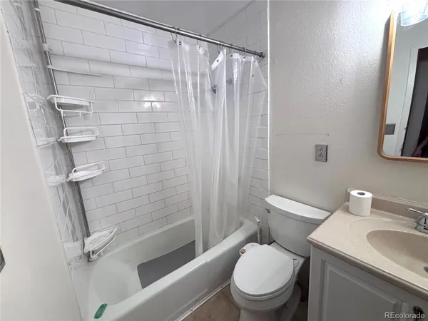a white toilet sitting next to a bath tub