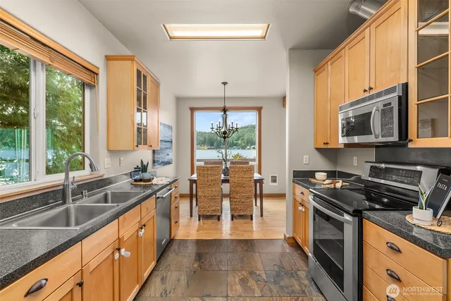 a kitchen with stainless steel appliances a stove sink microwave and cabinets