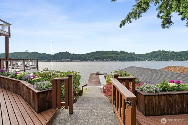 a view of a table and chairs on the roof deck with wooden fence