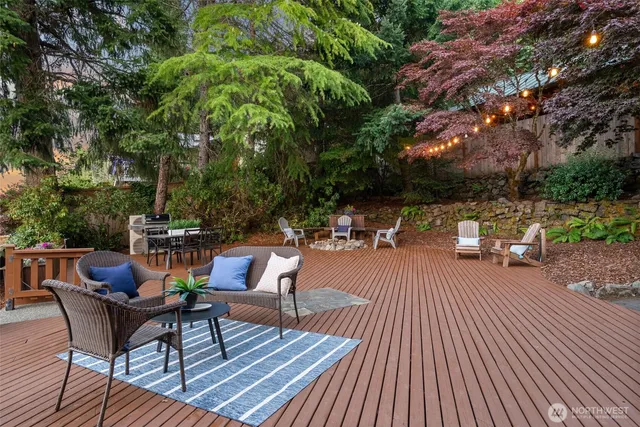 a view of a patio with table and chairs and couches with wooden floor and fence