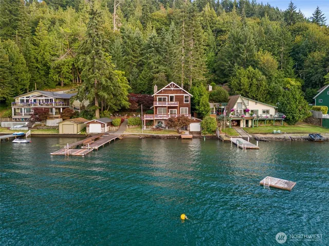 an aerial view of a house with swimming pool and lake view