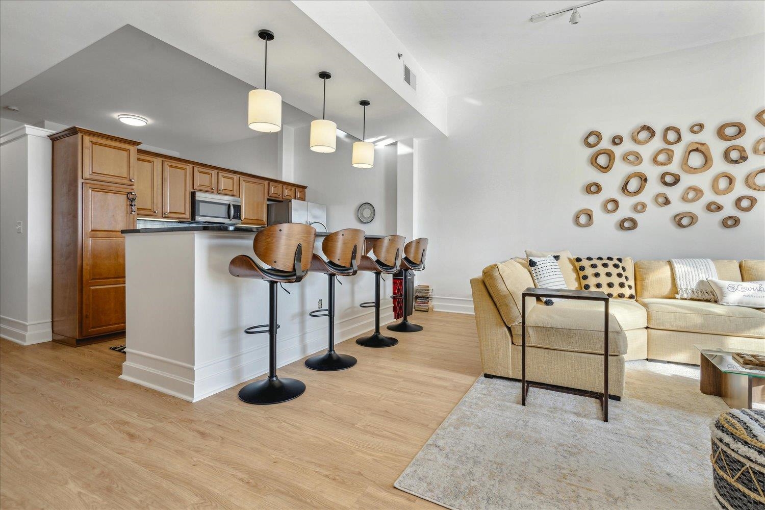 648 Riverside Drive, Unit 411 Memphis, TN 38103 - Photo 6 of 32 Kitchen featuring decorative light fixtures, light wood-type flooring, a breakfast bar area, and appliances with stainless steel finishes