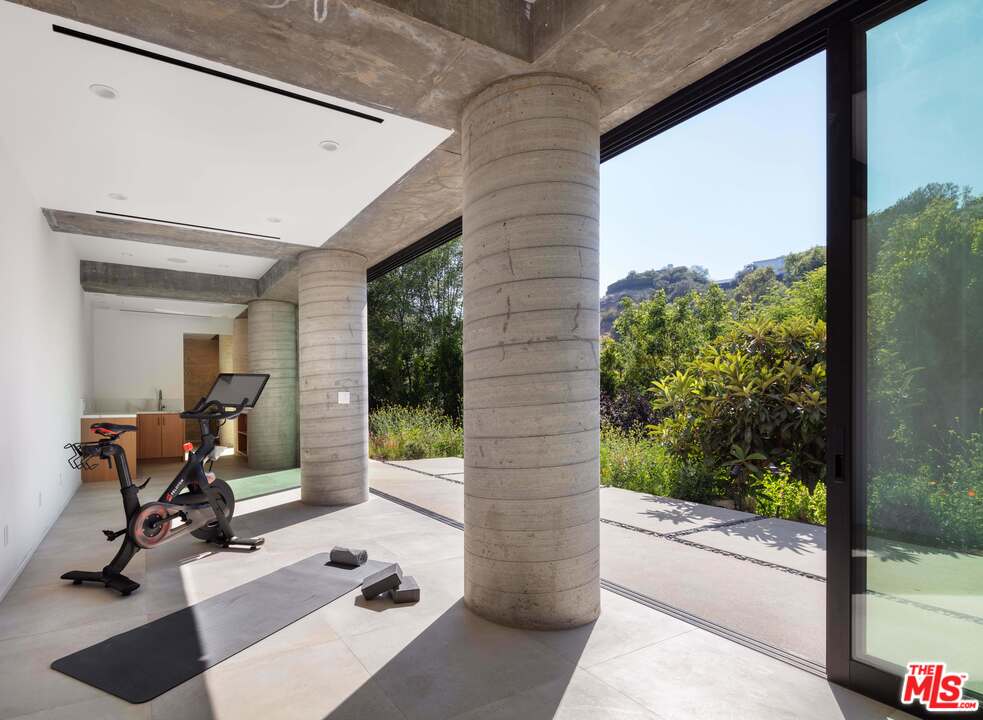 2600 Hutton Drive Beverly Hills, CA 90210 - Photo 28 of 29 a view of a patio with table and chairs and floor to ceiling window next to a yard
