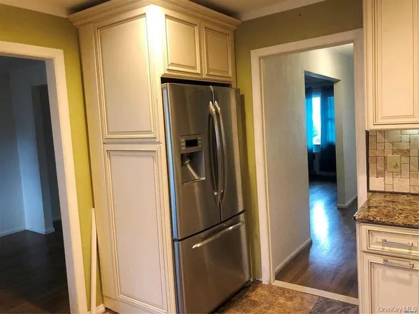 a metallic refrigerator freezer sitting in a kitchen
