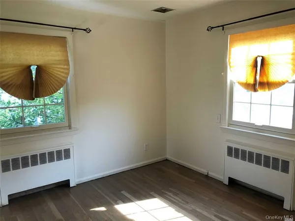 a view of a room with wooden floor and a window