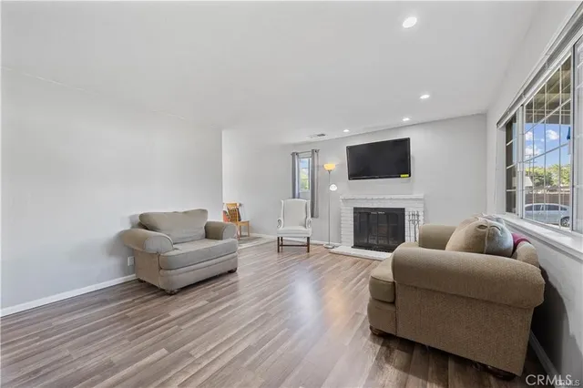 a living room with furniture a fireplace and a flat screen tv